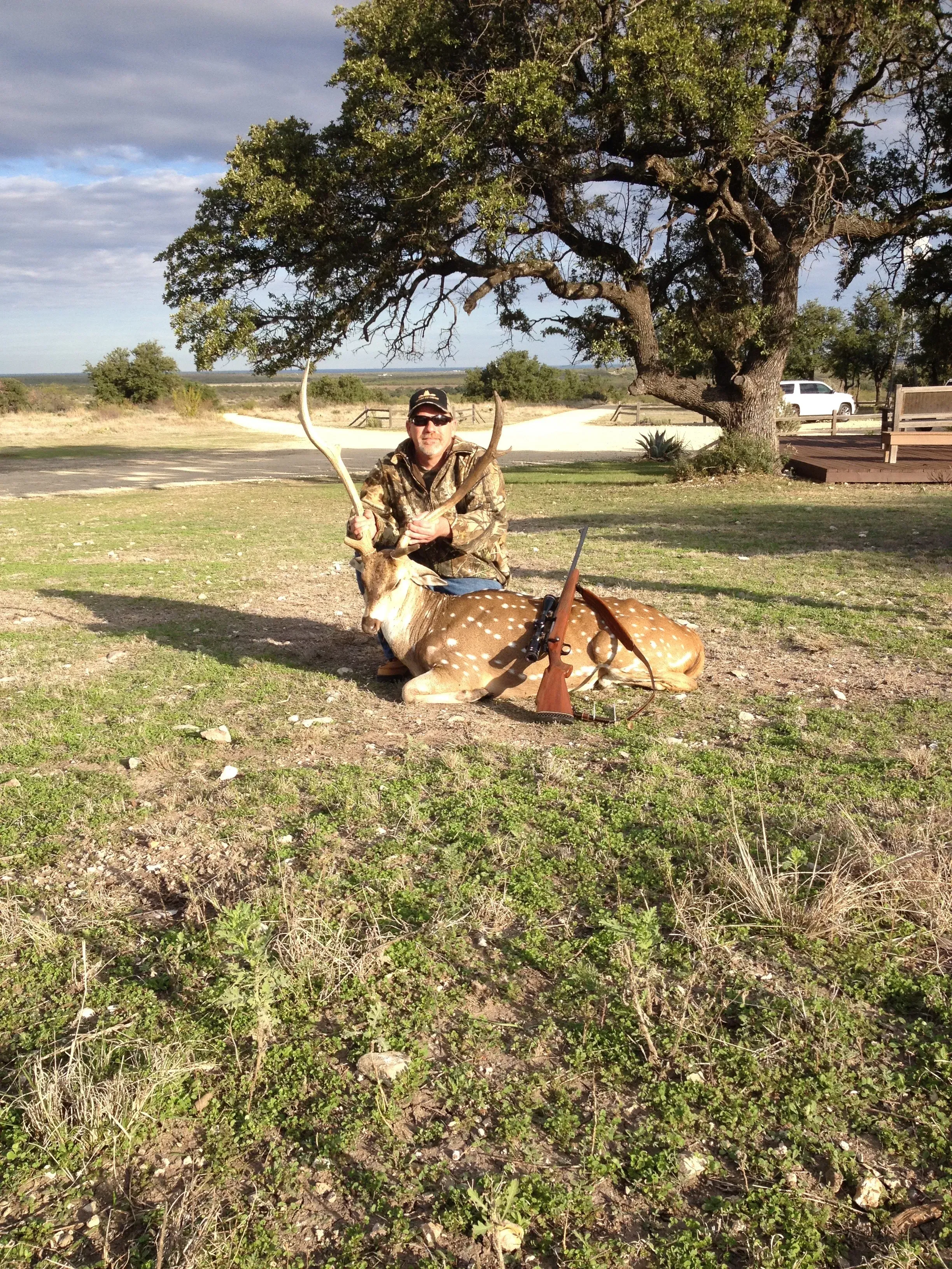 Hunter with trophy buck at sunset